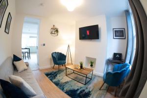a living room with blue chairs and a table at City Centre 2 Bed House Perfect for Contractors with Free Parking in Nottingham