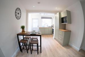 una cucina con tavolo, sedie e orologio sul muro di City Centre 2 Bed House Perfect for Contractors with Free Parking a Nottingham