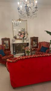 un divano rosso in un soggiorno con due sedie e uno specchio di La Volta a La Spezia