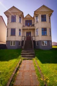 a large house with stairs in front of it at Guesthouse Holl in Vestmannaeyjar