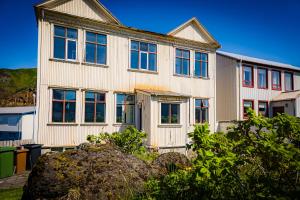 ein großes weißes Haus mit Fenstern in der Unterkunft Guesthouse Holl in Vestmannaeyjar