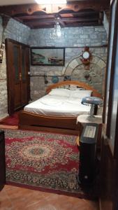 ein Schlafzimmer mit einem Bett und einem Teppich auf dem Boden in der Unterkunft Karafil Guesthouse in Gjirokastër
