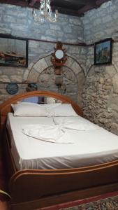 um quarto com uma cama numa parede de pedra em Karafil Guesthouse em Gjirokastër