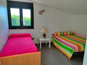 two beds with colorful sheets in a room at Mar infinito da Costa da Morte in O Pindo