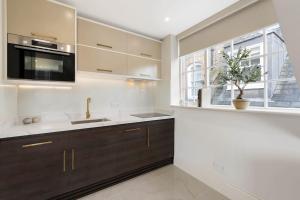 a kitchen with a sink and a microwave at Wonderful Knightsbridge Apartment by Harrods in London