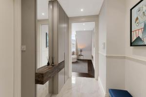 pasillo de una casa con espejo y escalera en Wonderful Knightsbridge Apartment by Harrods en Londres