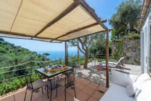 a patio with a table and chairs and a view of the ocean at YourHome - Relais Casa degli Angeli in Positano