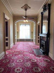 a large room with a red carpeted hallway with a fireplace at Upjohn in Kalamazoo