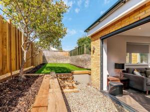 a small backyard with a tree and a couch at Walpole BACK House sleeps 6-8 in Margate