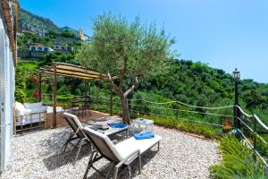 a patio with a table and chairs and a tree at YourHome - Relais Casa degli Angeli in Positano