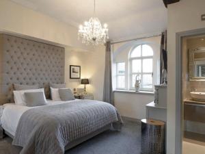 Un dormitorio con una cama grande y una lámpara de araña. en Old Chapel House, en Barnoldswick