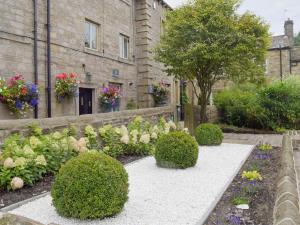 un jardín con arbustos y flores frente a un edificio en Old Chapel House, en Barnoldswick