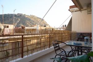 een balkon met een tafel en stoelen en een berg bij ILOS APARTMENT in Nafplio