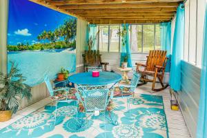 eine Veranda mit einem blauen Tisch und Stühlen in der Unterkunft New Concord Vacation Rental Near Kentucky Lake in New Concord