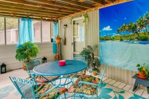 - une table et des chaises sur une terrasse couverte offrant une vue sur l'eau dans l'établissement New Concord Vacation Rental Near Kentucky Lake, à New Concord