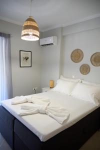 een slaapkamer met een groot bed met witte lakens bij ILOS APARTMENT in Nafplio