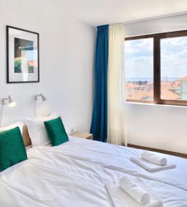 a bedroom with a large white bed with a window at Central Seaview Apartments for 4 Guests in Sveti Vlas