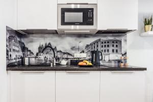 a kitchen counter with a painting of a city at Komfortowe apartamenty w centrum Wrocławia in Wrocław