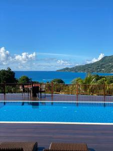 a swimming pool with a view of the water at D'Offay Seaview Apartments in Beau Vallon