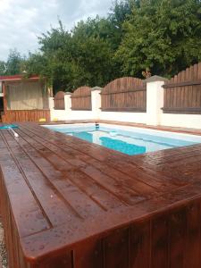 une piscine avec une terrasse en bois dans une arrière-cour dans l'établissement MONADIN Villa Relax & Spa, à Săcele