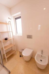 Baño blanco con aseo y lavamanos en Superb Central Lisbon Apartment, en Lisboa