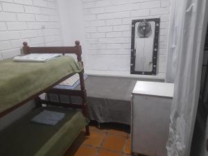 a small room with two beds and a mirror at Hostel Feel Home in Blumenau