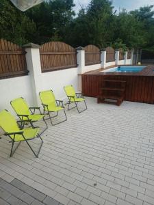 een groep stoelen naast een zwembad bij MONADIN Villa Relax & Spa in Săcele