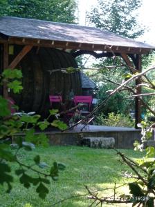 a wooden gazebo with two pink chairs in it at les tonneaux de Lisores in Lisores +7 photos