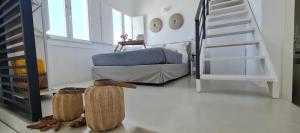 a bedroom with a bed and a staircase in a room at Lemon Tree Houses in Áno Meriá