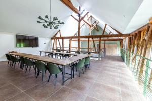 una sala da pranzo con tavolo in legno e sedie verdi di Hameau des 40 arpents a Gergy