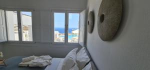 a bedroom with a bed and a view of the ocean at Lemon Tree Houses in Áno Meriá