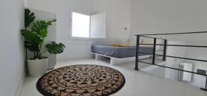 a white room with a bed and a rug at Lemon Tree Houses in Áno Meriá