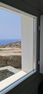 an open window with a view of the ocean at Lemon Tree Houses in Áno Meriá
