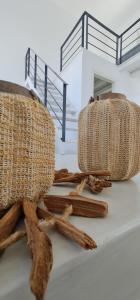 two baskets and sticks on the floor next to a staircase at Lemon Tree Houses in Áno Meriá