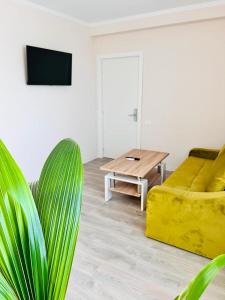 een woonkamer met een gele bank en een tafel bij KIR House On The Beach in Eforie Nord