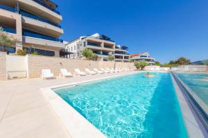 a person swimming in a swimming pool next to a building at Apartman Seaside 5 in Banjole