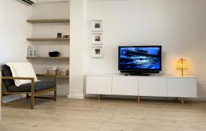 een woonkamer met een tv op een witte kast bij Apartamento de 3 habitaciones a 100 m de la playa del Arenal, Javea in Platja de l'Arenal