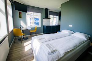 a bedroom with a large white bed and a desk at Guesthouse Holl in Vestmannaeyjar