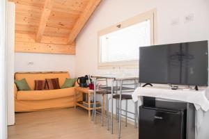 ein Wohnzimmer mit einem Tisch und einem TV in der Unterkunft Villa Marianna in Alghero