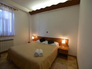 een slaapkamer met een bed met twee witte schoenen erop bij Bassanese Kastel in Kaštel