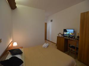 a bedroom with a bed and a tv on a desk at Bassanese Kastel in Kaštel