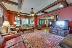 sala de estar con TV grande y sofá en Historic Auburn House on 37 Acres with Private Lake!, en Auburn
