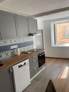 - une cuisine avec un comptoir et une cuisinière four supérieur dans l'établissement Grand appartement hyper centre Grasse, à Grasse