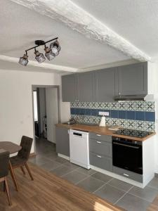 uma cozinha com um fogão e uma mesa com cadeiras em Grand appartement hyper centre Grasse em Grasse