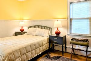1 dormitorio con 1 cama, 2 lámparas y ventana en Garden Hideaway, en Wiscasset