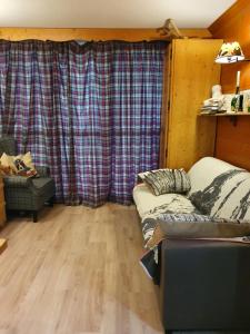 uma sala de estar com um sofá e cortinas xadrez em 2 pièces Valloire pied des pistes em Valloire