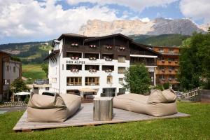un grand bâtiment avec deux canapés devant lui dans l'établissement Hotel Des Alpes, à La Villa