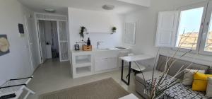 a white kitchen with a sink and a table at Lemon Tree Houses in Áno Meriá