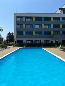 a large swimming pool in front of a building at Sunlight Studio in Balatonföldvár +3 photos