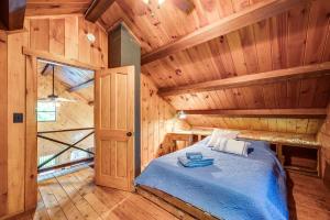 a bedroom with a bed in a wooden cabin at North Haverhill Cabin with Fire Pit and Grill! 